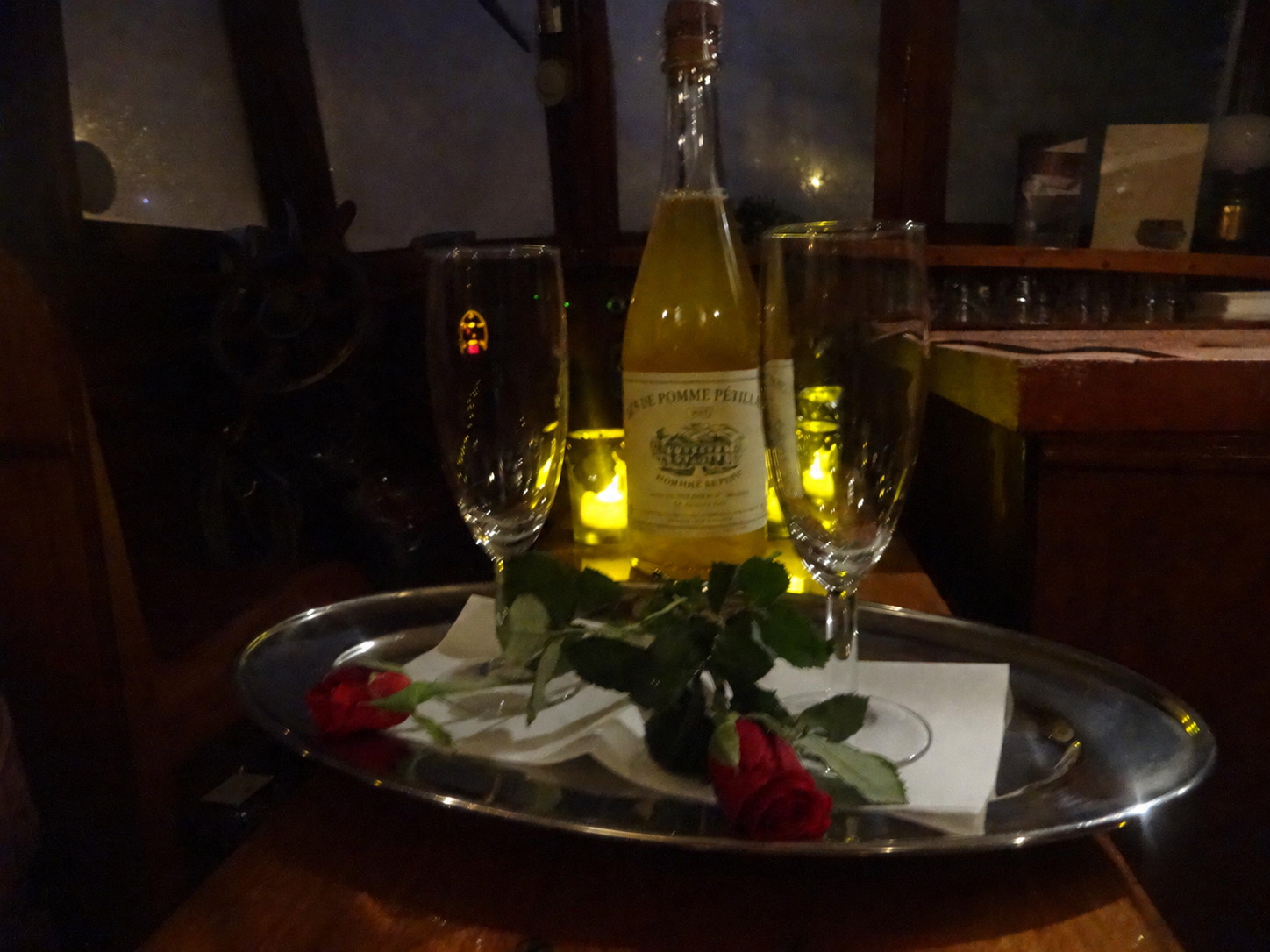 Glazen, een fles en rozen bij sfeerverlichting aan boord
